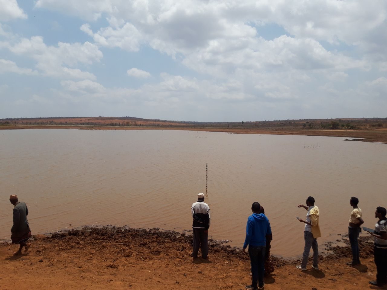 Community members observing a water body, representing water security and climate resilience.